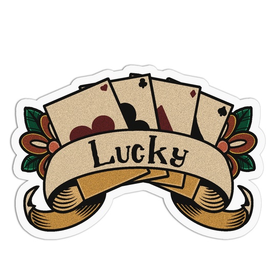 A die-cut sticker featuring a traditional tattoo-style illustration with four fanned playing cards, a ribbon banner reading 'Lucky,' and decorative leaves on both sides, shown on a plain white background.