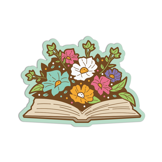 A die-cut sticker or graphic illustration of an open book with flowers growing from the pages. The design features a light green border, brown soil, and flowers in pink, white, yellow, and blue with green leaves, shown on a plain white background.