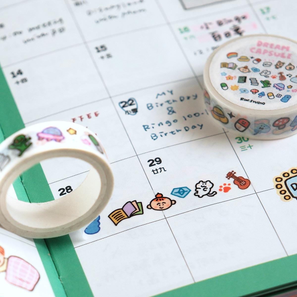 Two rolls of decorative tape with cartoon designs on a calendar background