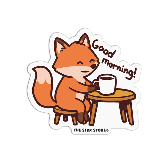 Sticker of a fox holding a coffee cup with 'Good morning!' text, from THE STKR STORE.