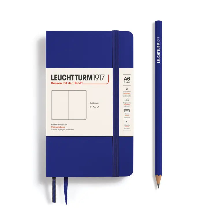 Blue notebook with white label and matching pencil on a white background