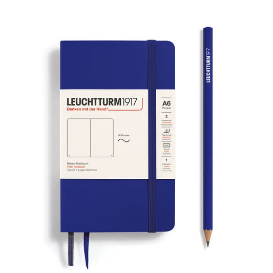 Blue notebook with white label and matching pencil on a white background