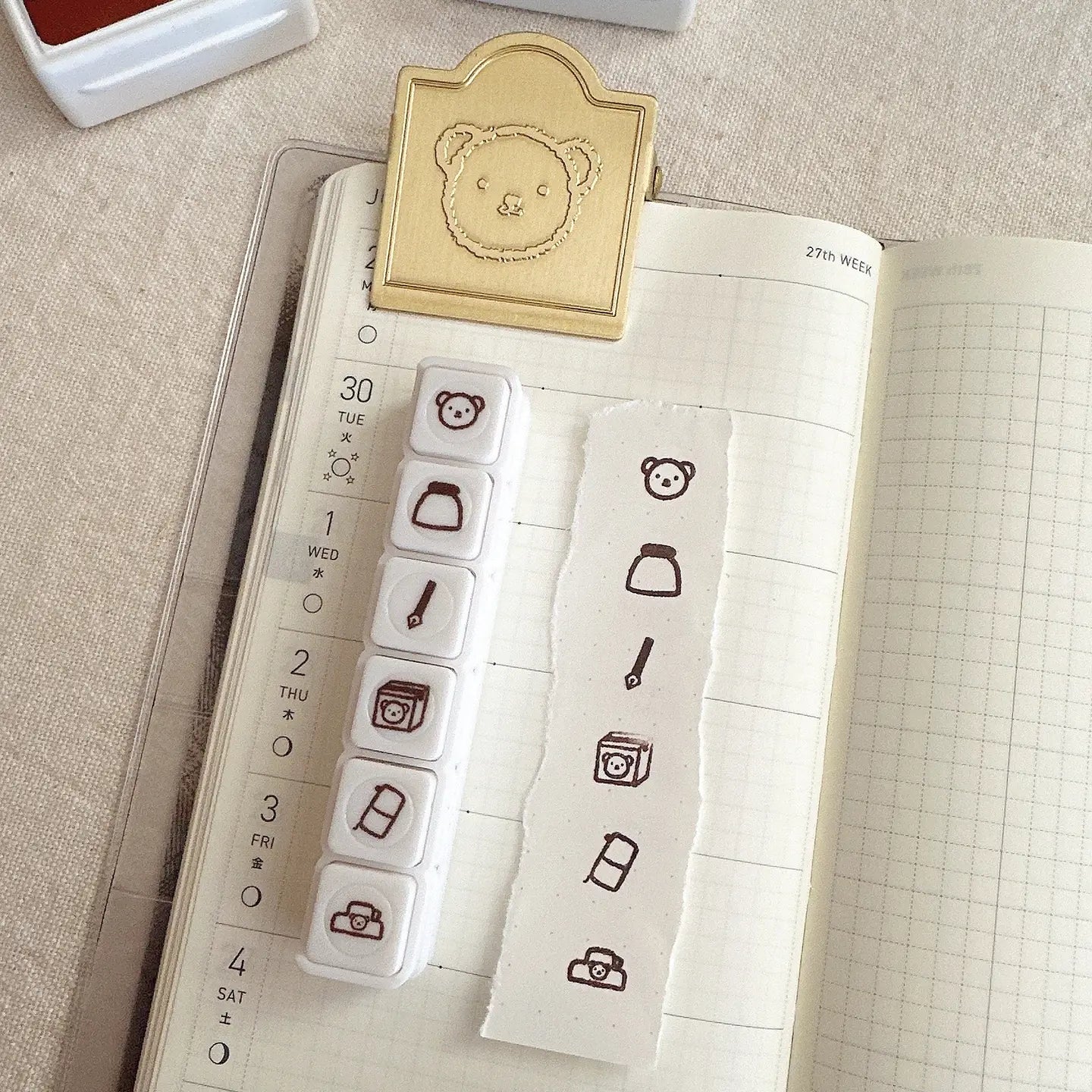 Stamps with bear and icon designs on a notebook page