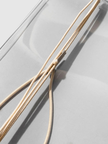 Two thin beige sticks on a light gray surface