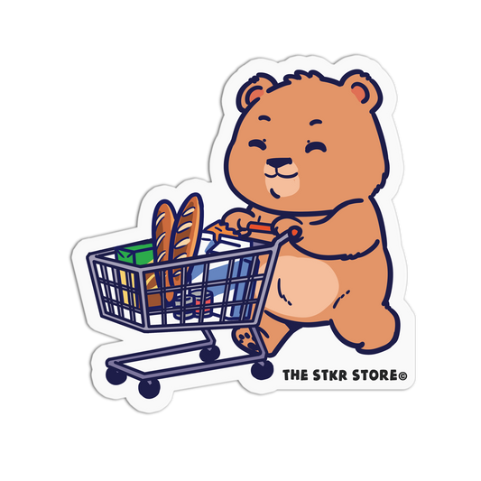 Cartoon bear pushing a shopping cart with bread and groceries, from The STKR Store.