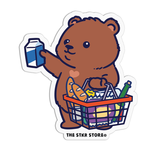 Cartoon bear holding a milk carton and a shopping basket with groceries on a white background, branded 'THE STKR STORE'.