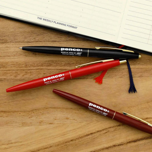 black red and burgundy pens on wooden table