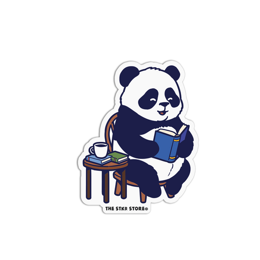 Sticker of a panda reading a book with a cup and books on a table, branded 'The Stkr Store'.