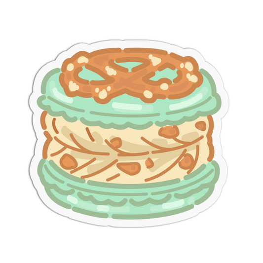 A die-cut sticker featuring a cute, cartoon-style illustration of a macaron with a pretzel topping, set against a plain white background.