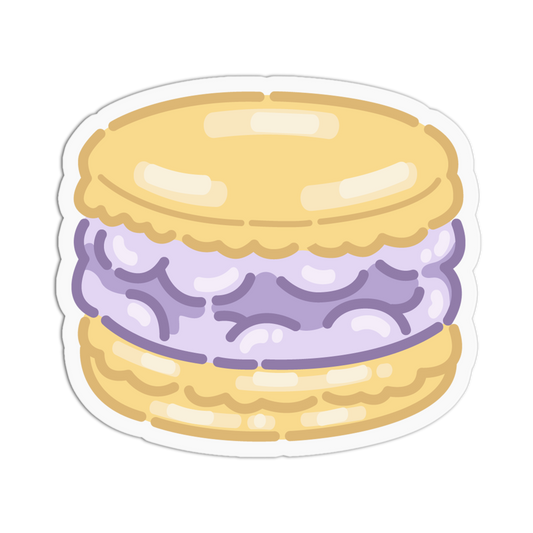 A die-cut sticker featuring a cute, cartoon-style illustration of a macaron. The macaron has a light yellow shell and a lavender-purple filling, presented on a clean white background.