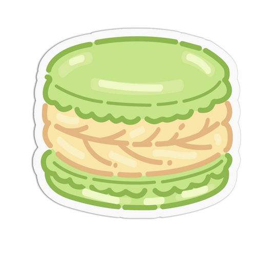 A die-cut sticker featuring a cute, cartoon-style green macaron with a light beige filling, shown on a solid white background.