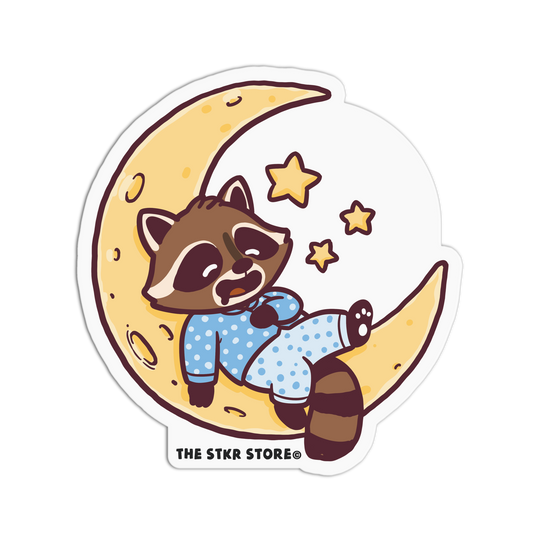 Sticker of a raccoon in pajamas on a moon with stars, from The Stkr Store.