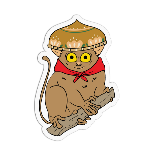 A die-cut cartoon sticker of a brown monkey wearing a tan sombrero and a red neckerchief, sitting on a log against a white background.